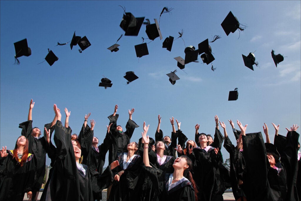 Graduates throwing up their caps into the air