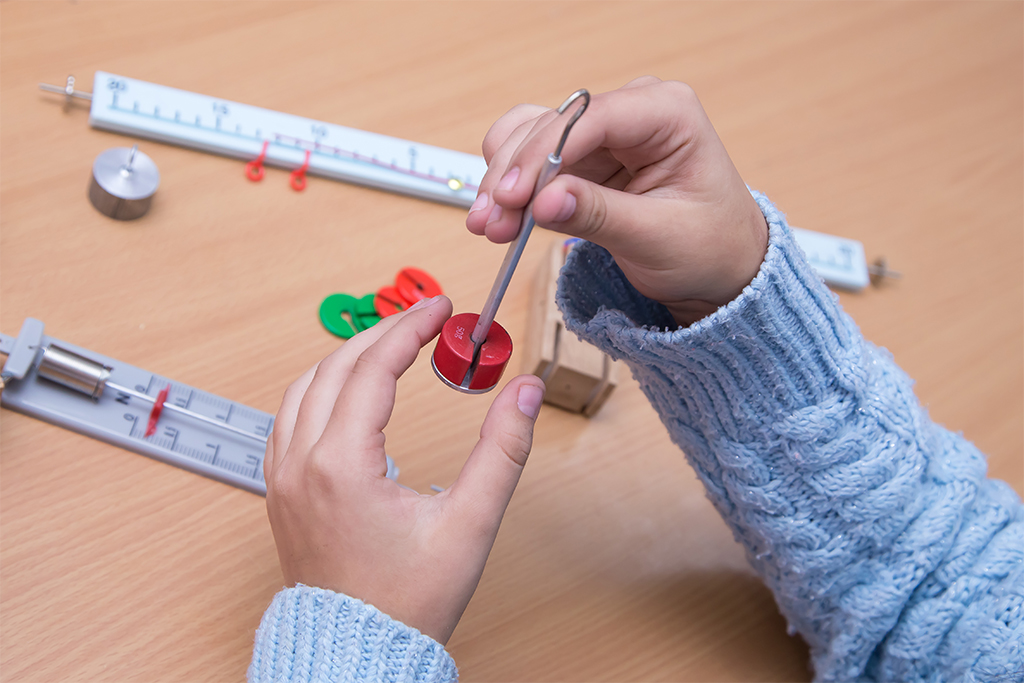 Close-up of hands holding a physics model.